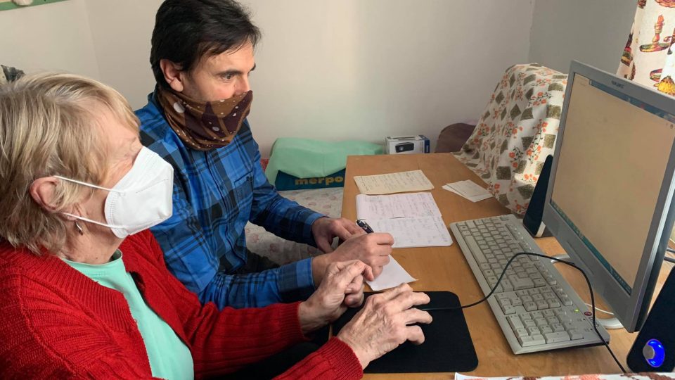 Paní Olze pomáhá s počítačem farář Československé církve husitské