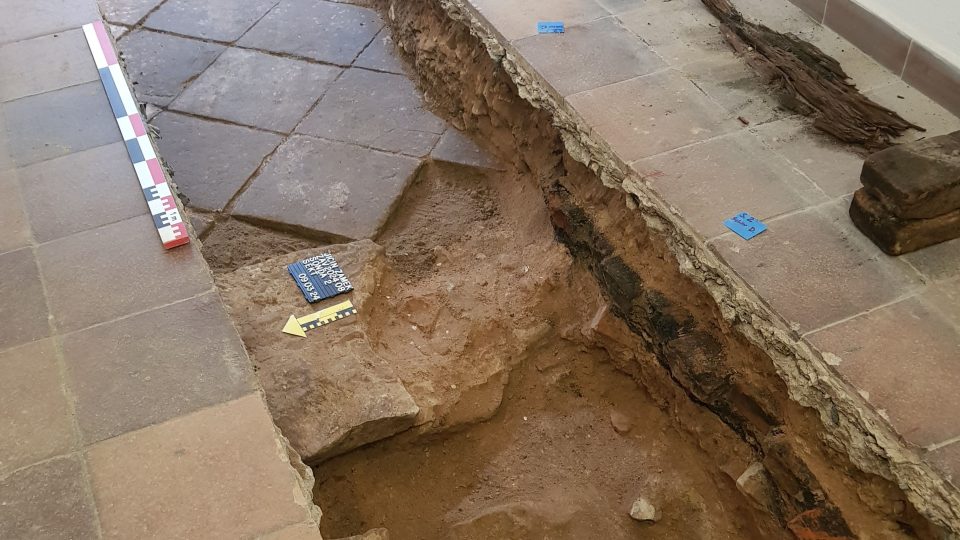 Archeologové dokumentují vrstvy ve výkopu v přízemí Valdštejnského paláce v Jičíně
