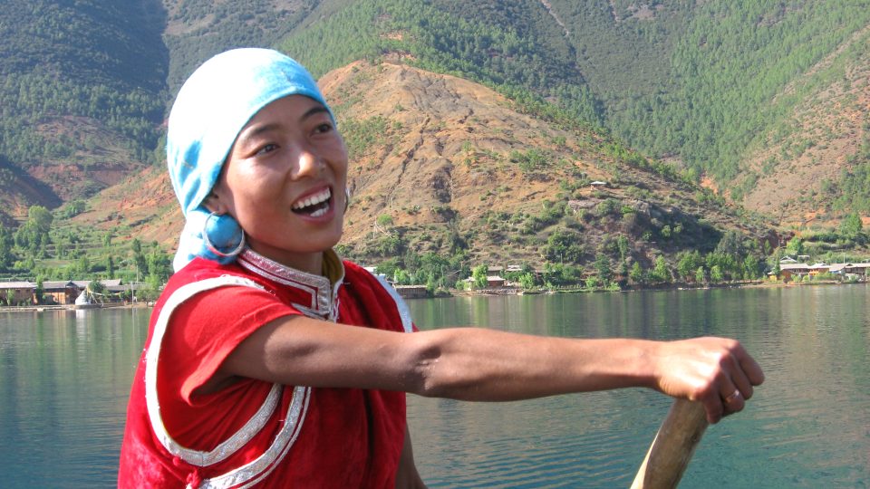 Mladá Mosujka zpívá na jezeře milostné písně, jezero Lugu, Čína