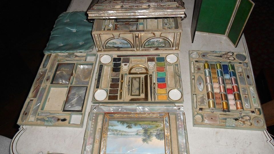 Perletí pokrytá a malbami zdobená skříňka, ve které je uloženo vše, co dáma 19. století potřebovala ke kratochvilnému konání