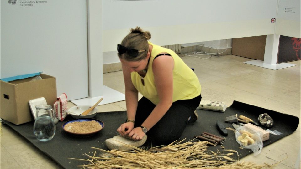 Archeoložka Lucie drtí zrní na mouku