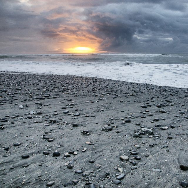 Slunce nízko nad obzorem na novozélandské pláži | foto: Michal Kroužel