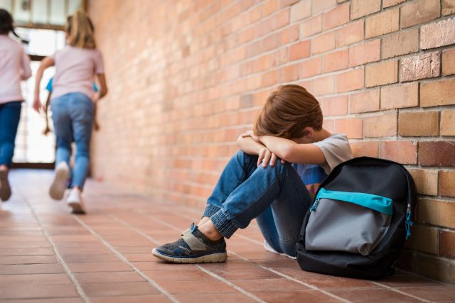 Šikanovaný chlapec pláče na školní chodbě | foto: Profimedia