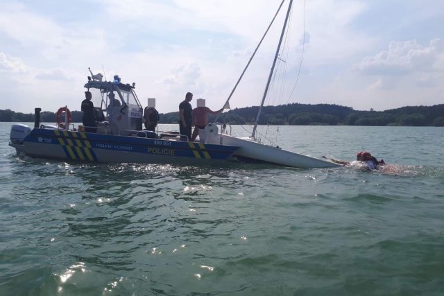 Převrácená plachetnice a posádka ve vodě. Úspěšná záchranná akce na Rozkoši | foto: Policie ČR