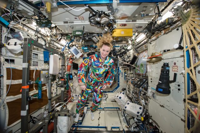 Americká astronautka Kate Rubinsová během svého minulého pobytu na ISS v roce 2016 je oblečená v pracovním overalu,  který pomalovali onkologicky nemocné děti z Anderson Cancer Center v Houstonu | foto: NASA